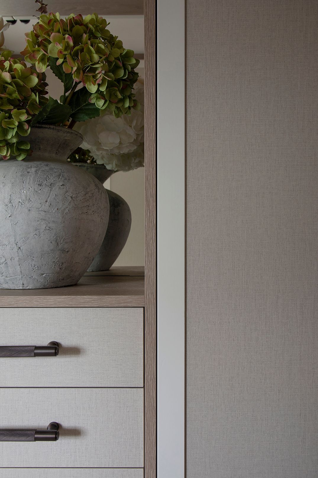 Styled wardrobe niche with grey ceramic vase, hydrangeas, and oak shelving - Elisa Design Welwyn Garden City