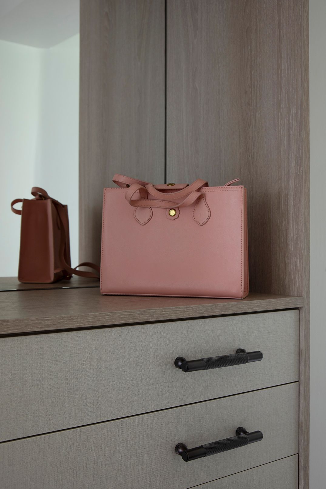 Wardrobe interior styling with pink leather handbag on oak shelf with brass knurled handles - Elisa Design