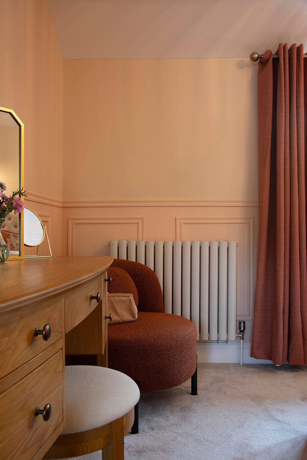 Master bedroom dressing area with oak furniture, rust bouclé chair, and brass pendant lighting - Elisa Design