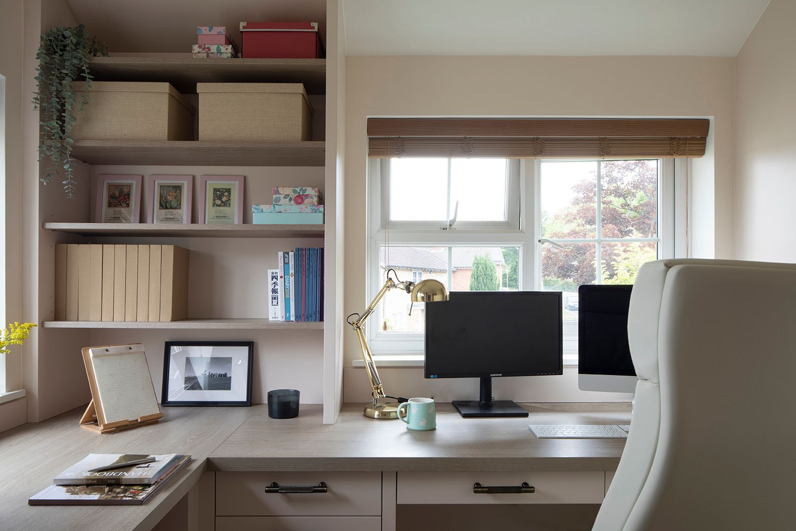 Custom home office workspace with brass task lamp, dual monitors, and styled oak shelving - Elisa Design interior design