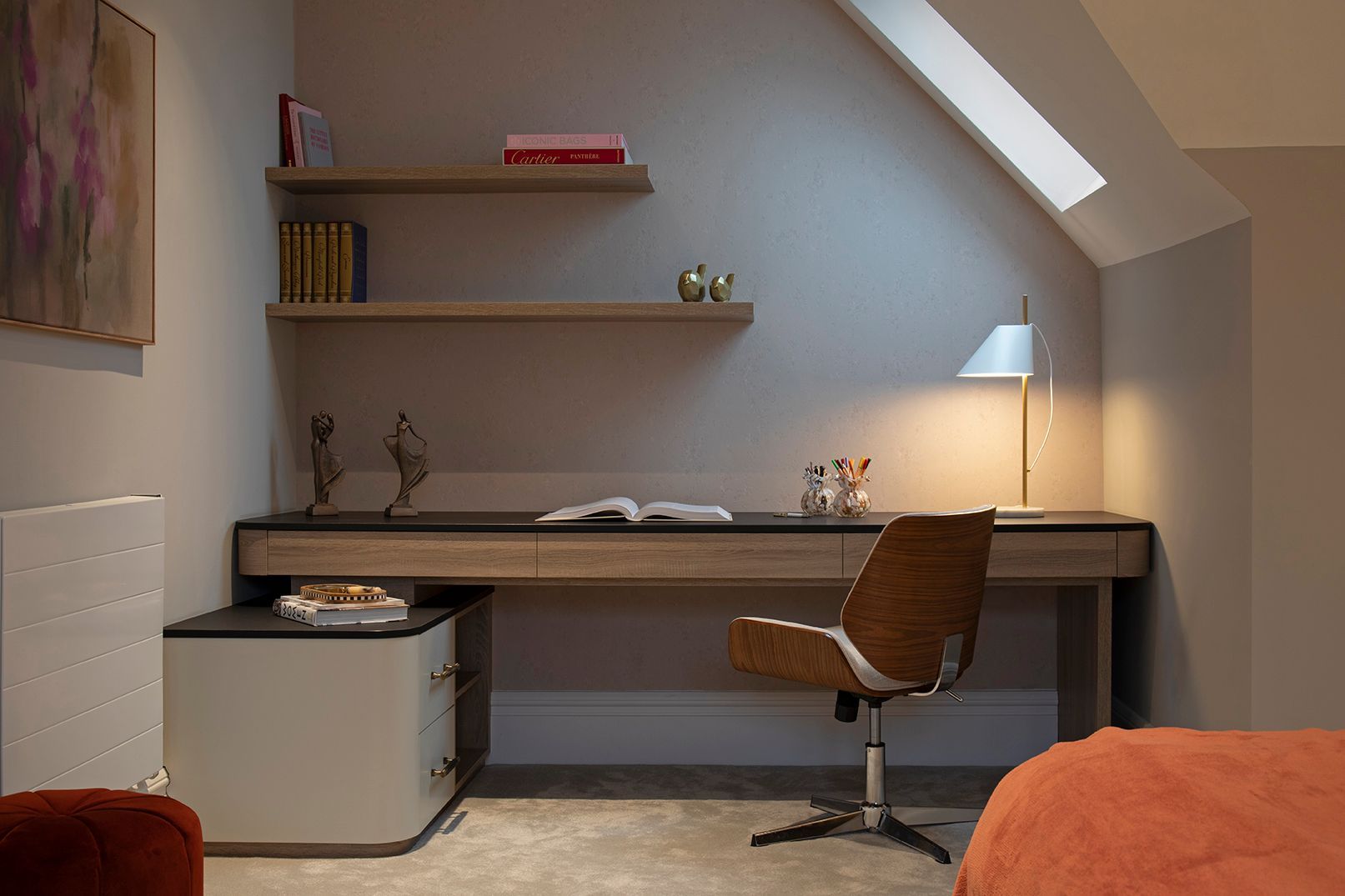 Bespoke floating desk with black countertop, oak shelving, and skylight in Bushey loft home office by Elisa Design