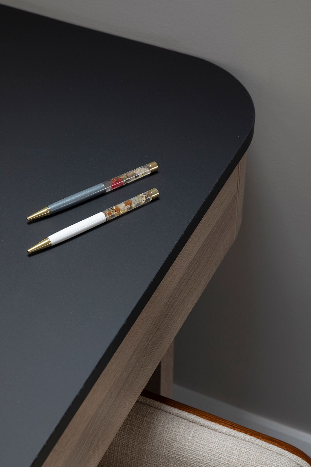 Designer pens detail on black desk surface in Bushey loft home office with bespoke joinery