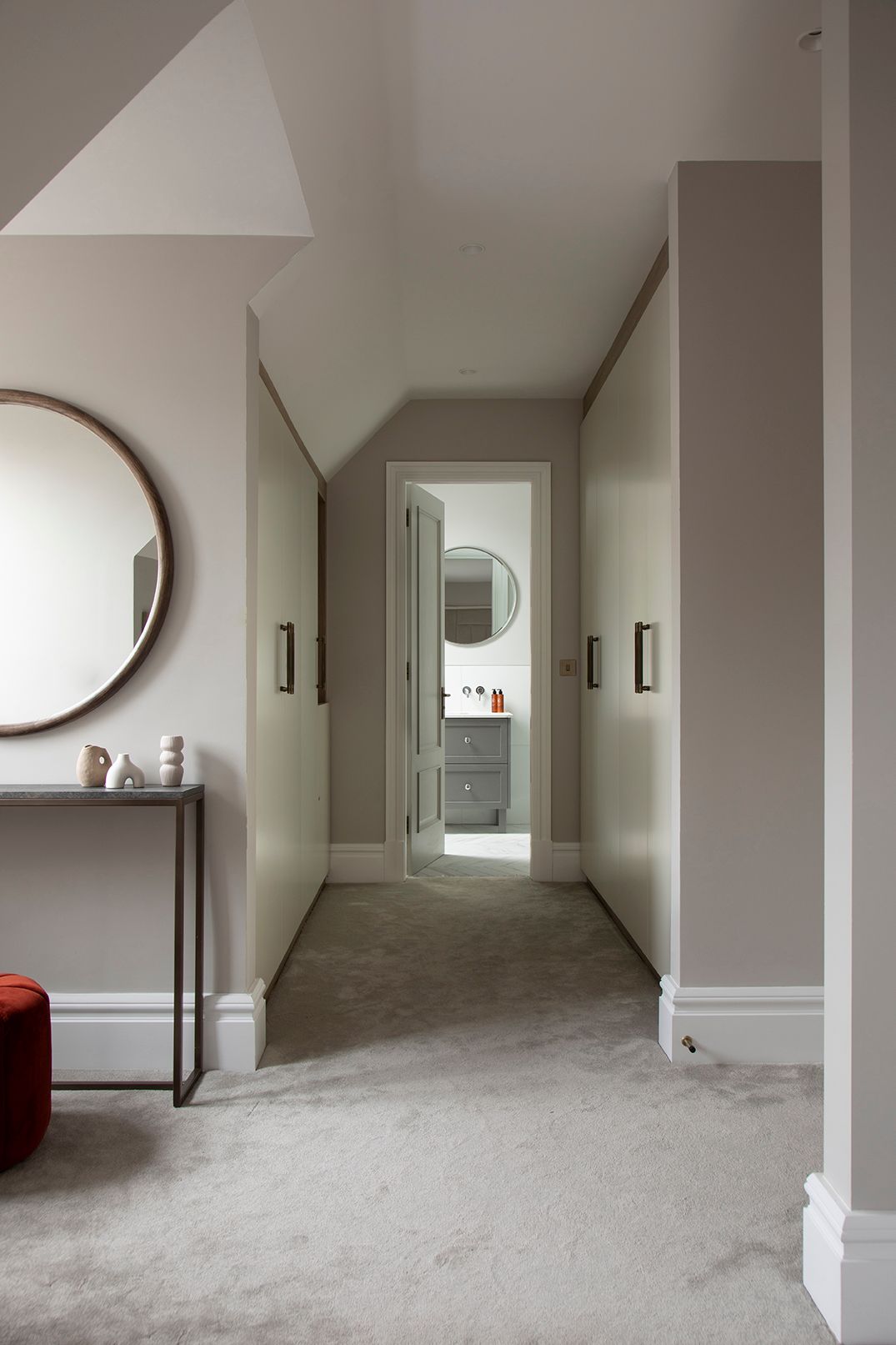 Loft corridor with floor-to-ceiling bespoke wardrobes and view through to ensuite in Bushey loft conversion