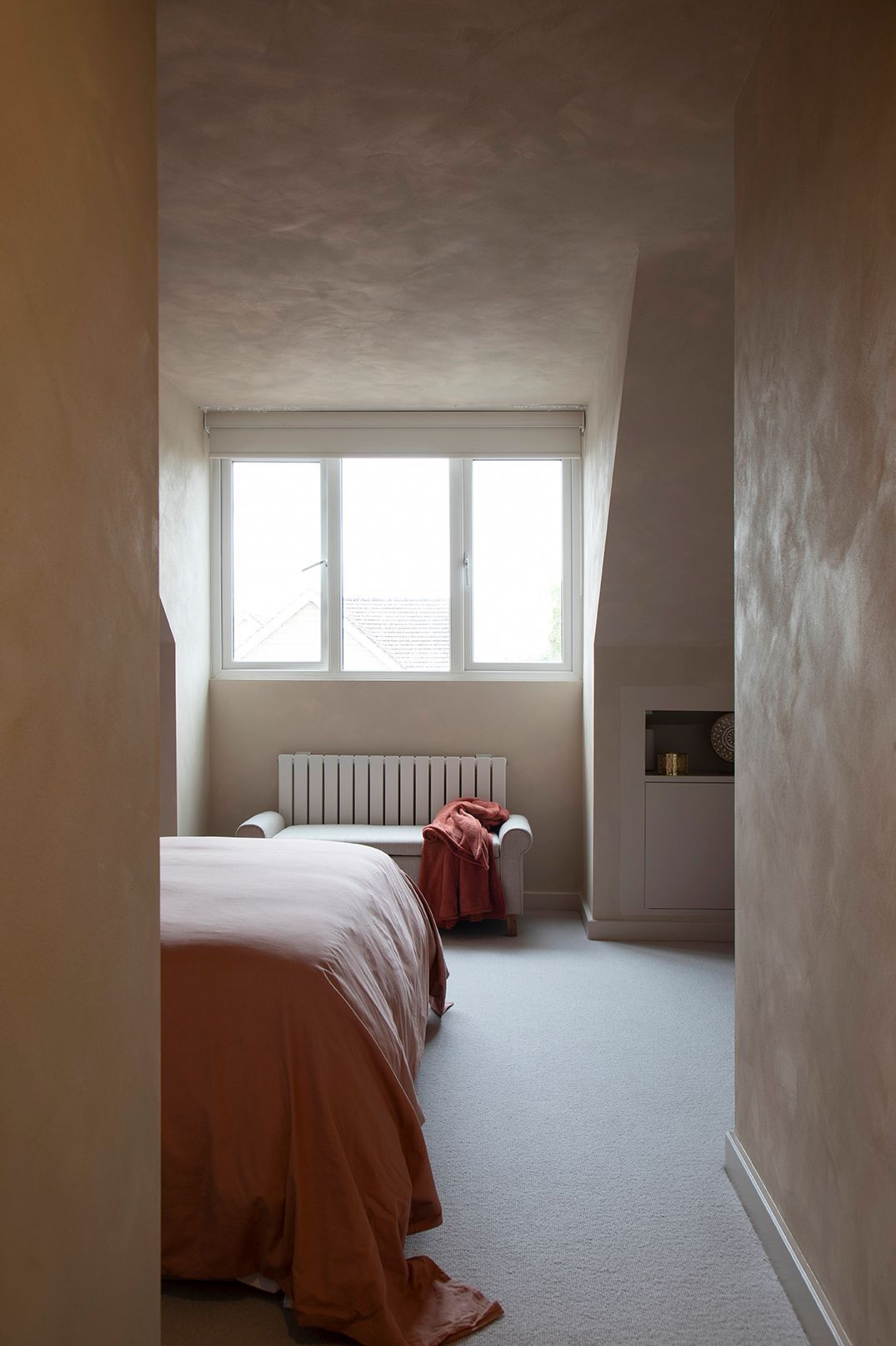 Loft bedroom with natural light, limewash walls, and bespoke oak storage in Watford conversion