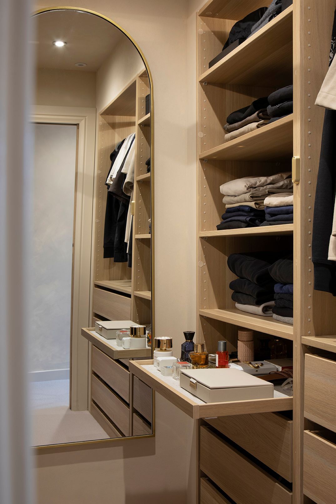 Elegant dressing area with makeup shelf, mirror, and oak cabinetry — a contemporary interior design feature in Watford.