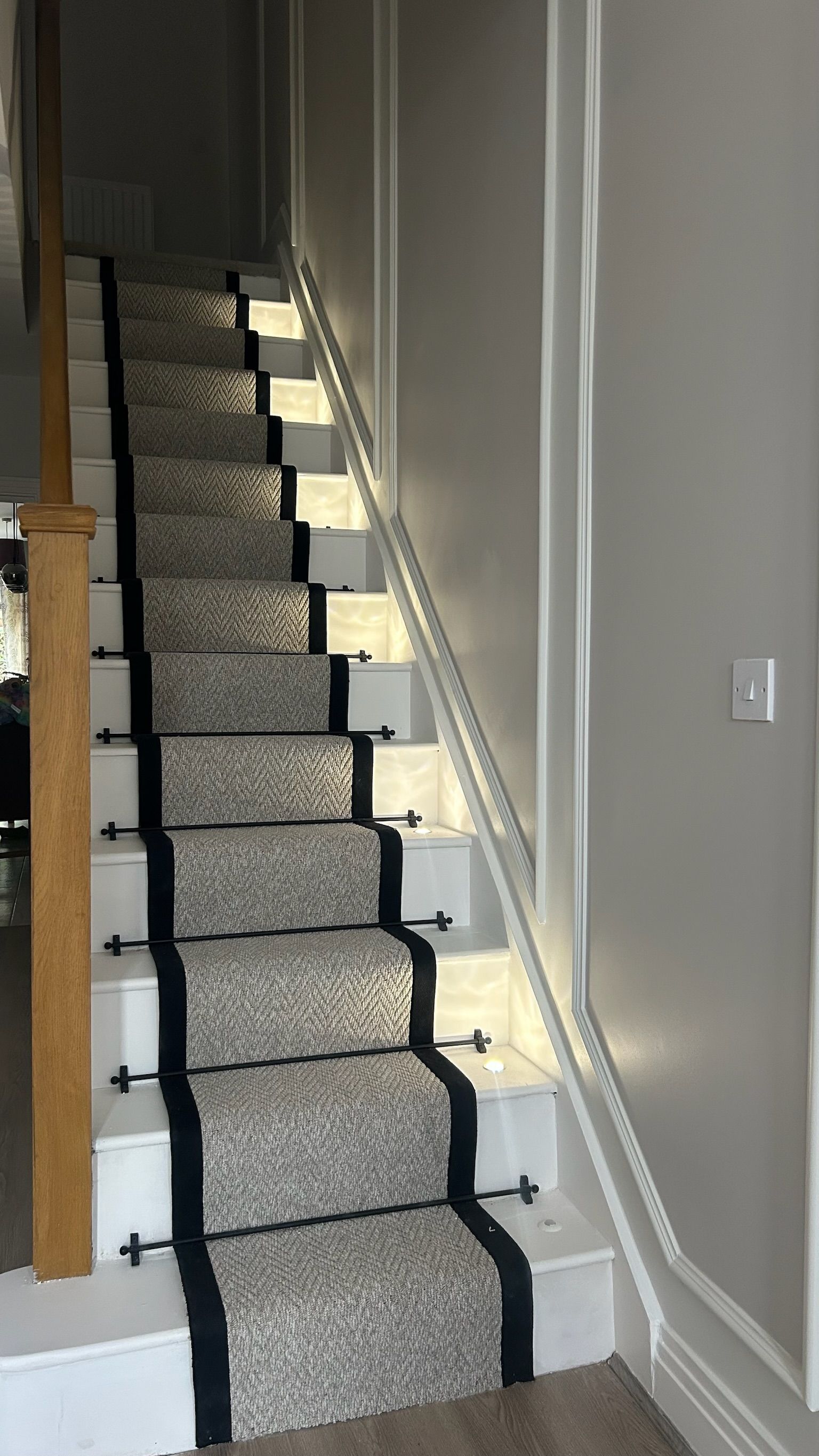 Welwyn hallway staircase with designer runner, integrated LED wall panelling, and contemporary balustrade.