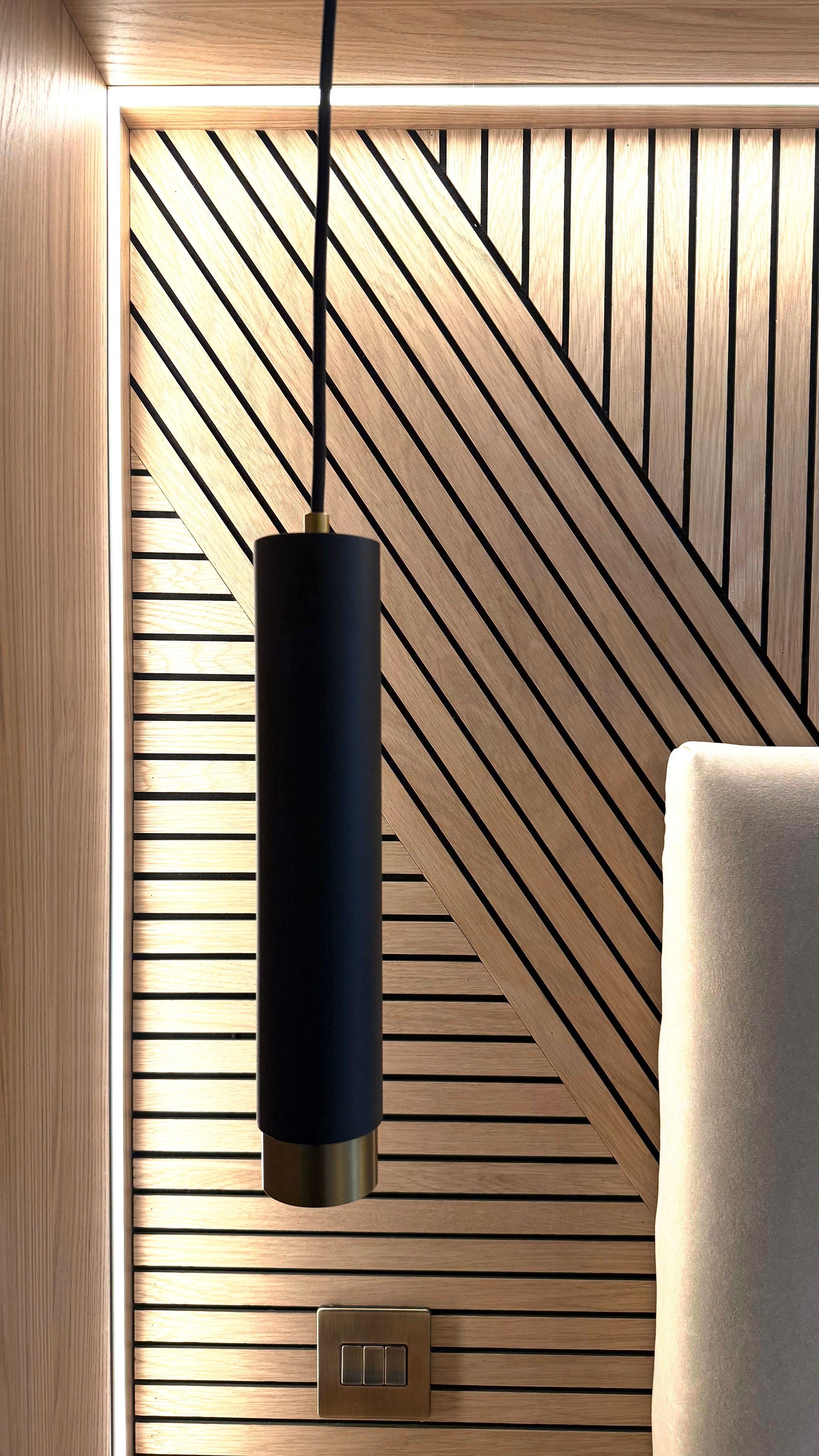 Close‑up of slatted timber headboard with diagonal black inlays and integrated LED strip in The Welwyn Family Edit.