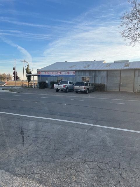two trucks are parked in front of a building on the side of the road .