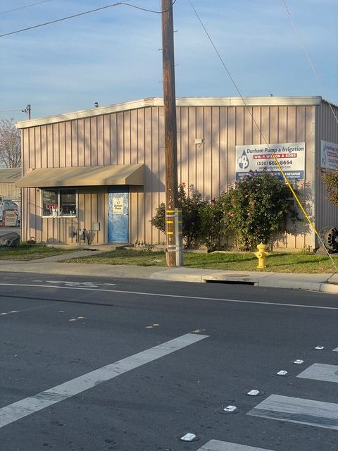 a brown building with a sign that says dunham pump & irrigation