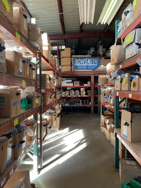 a warehouse filled with lots of boxes and a sign that says bowsmith