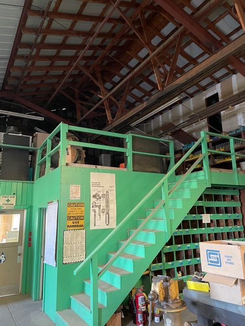 a green staircase with a caution sign on the wall