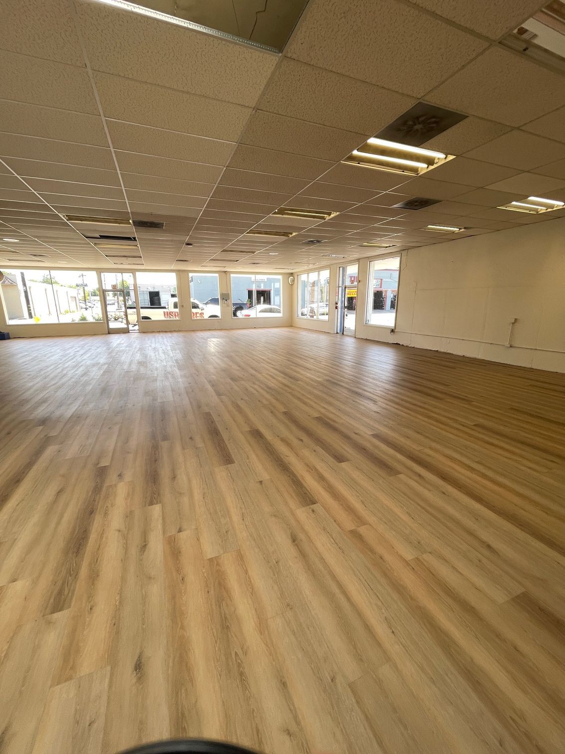 A large empty room with wooden floors and white walls.