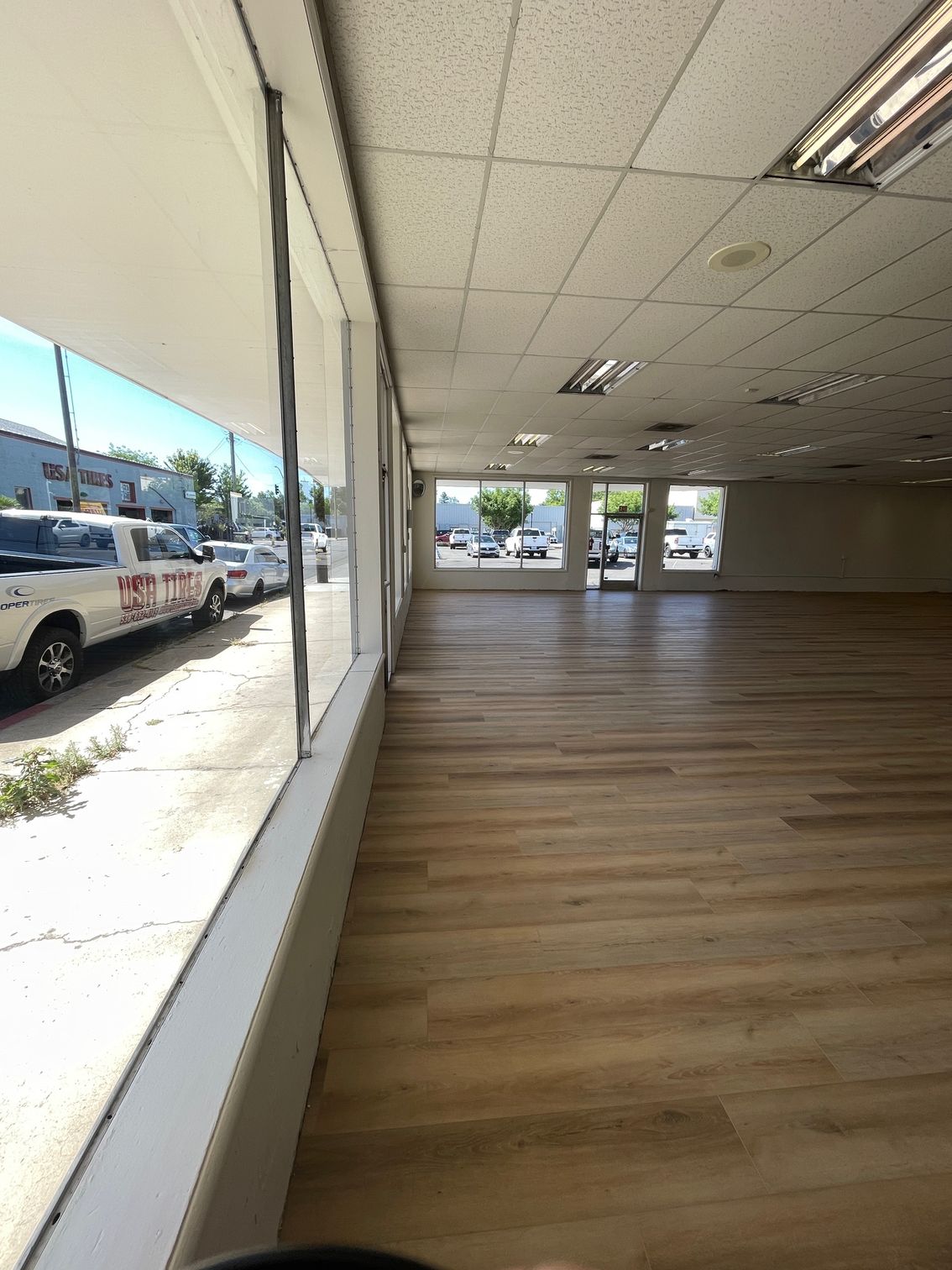 A large empty room with hardwood floors and a lot of windows.