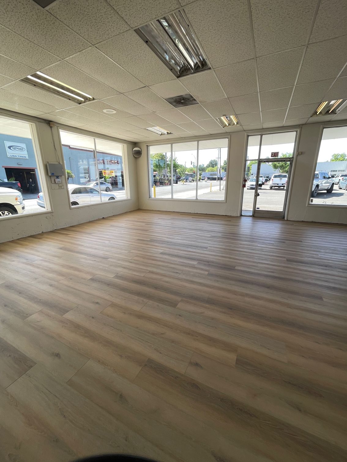 A large empty room with hardwood floors and lots of windows.