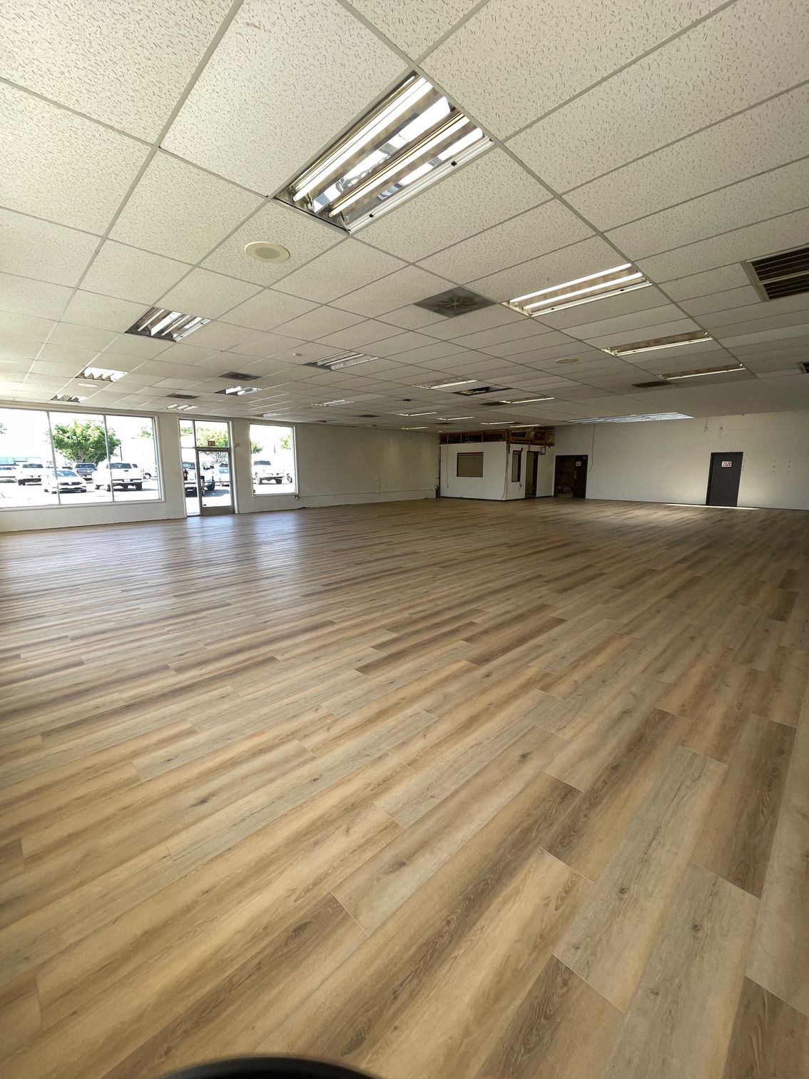 A large empty room with wooden floors and a white ceiling.