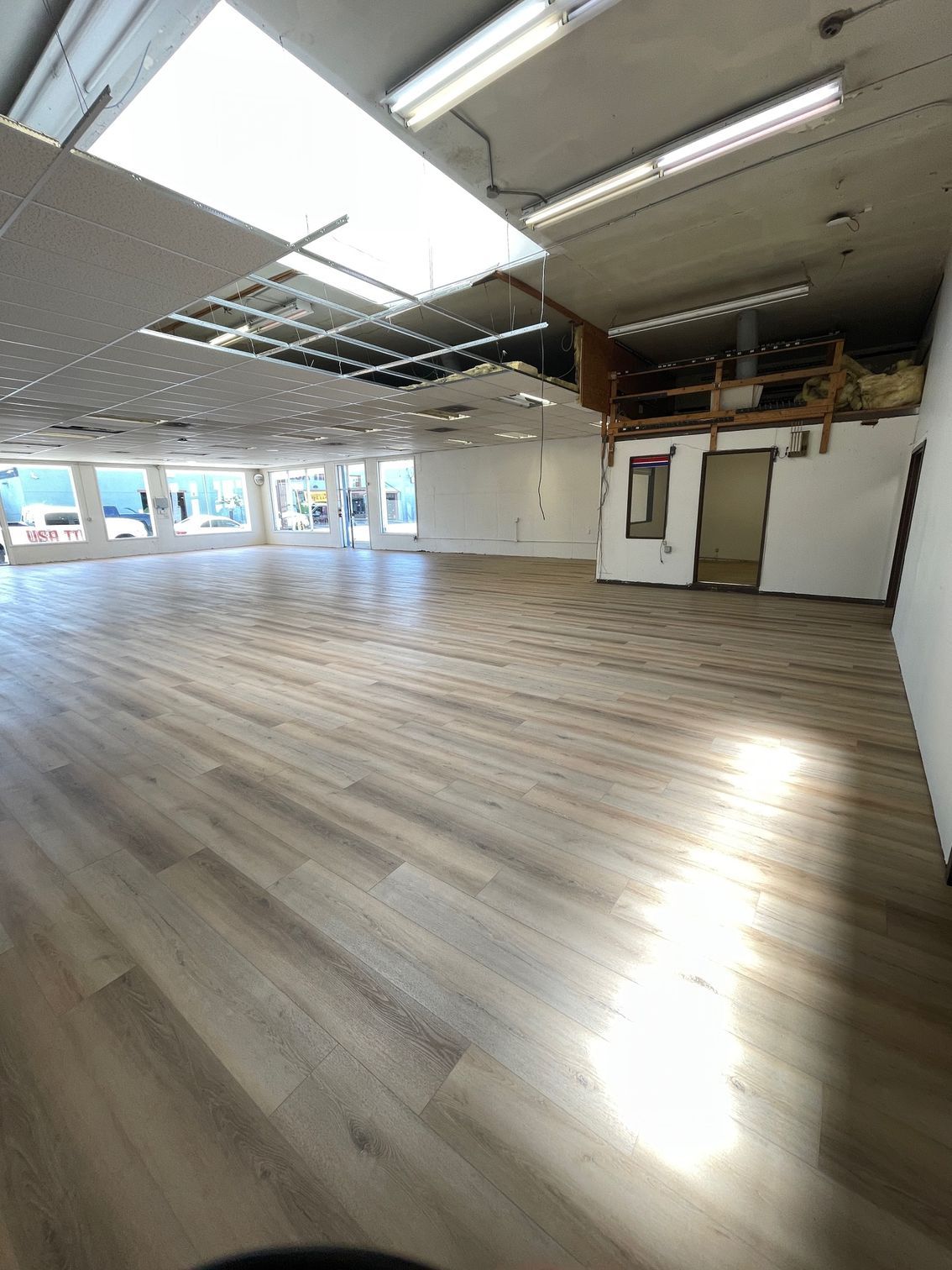 A large empty room with hardwood floors and a skylight.