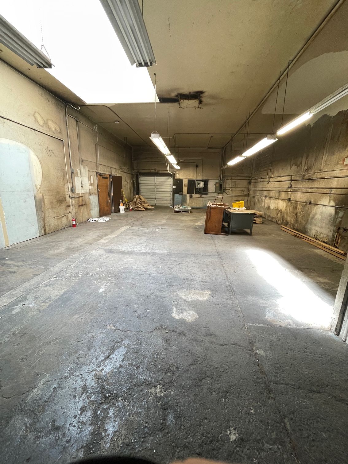 A large empty warehouse with a lot of lights on the ceiling.