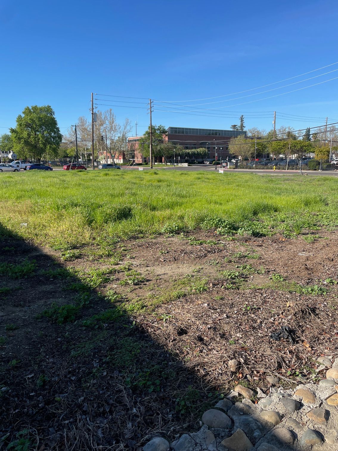 A large grassy field with a building in the background.