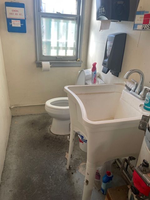 A bathroom with a sink a toilet and a window