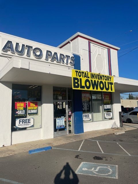 An auto parts store with a yellow sign that says total inventory blowout