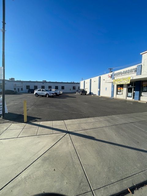 A parking lot with cars parked in front of a building
