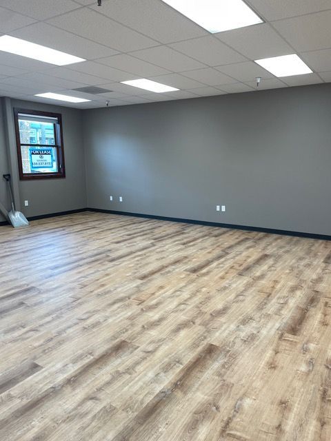 An empty room with hardwood floors and a window