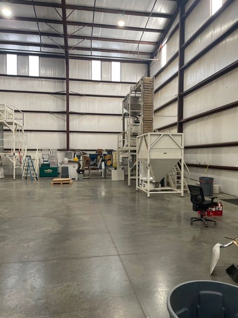 Large industrial warehouse with processing equipment and open floor space.