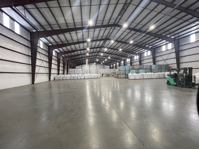 Warehouse interior with white sacks and forklift.