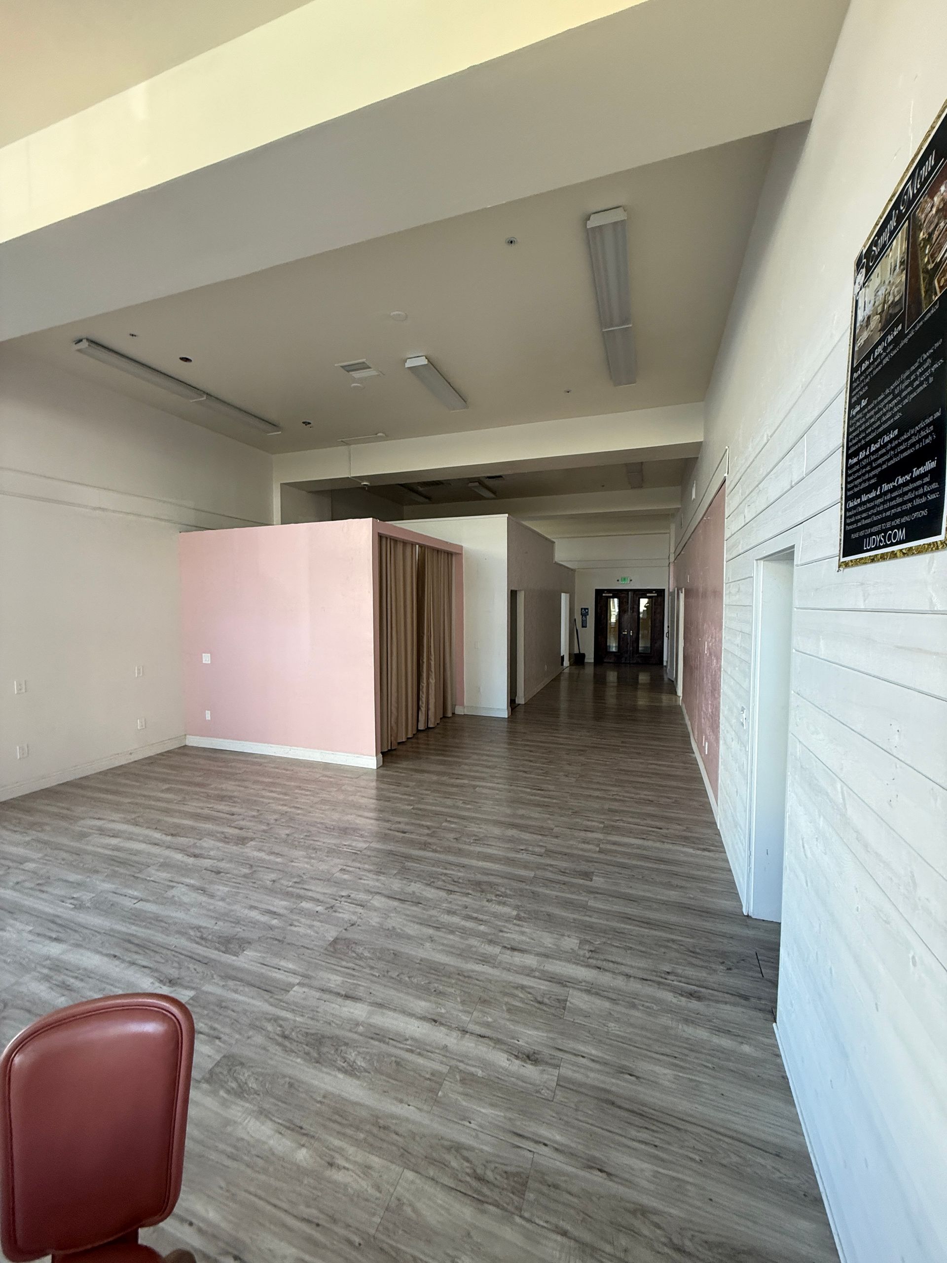 A large empty room with wooden floors and white walls.