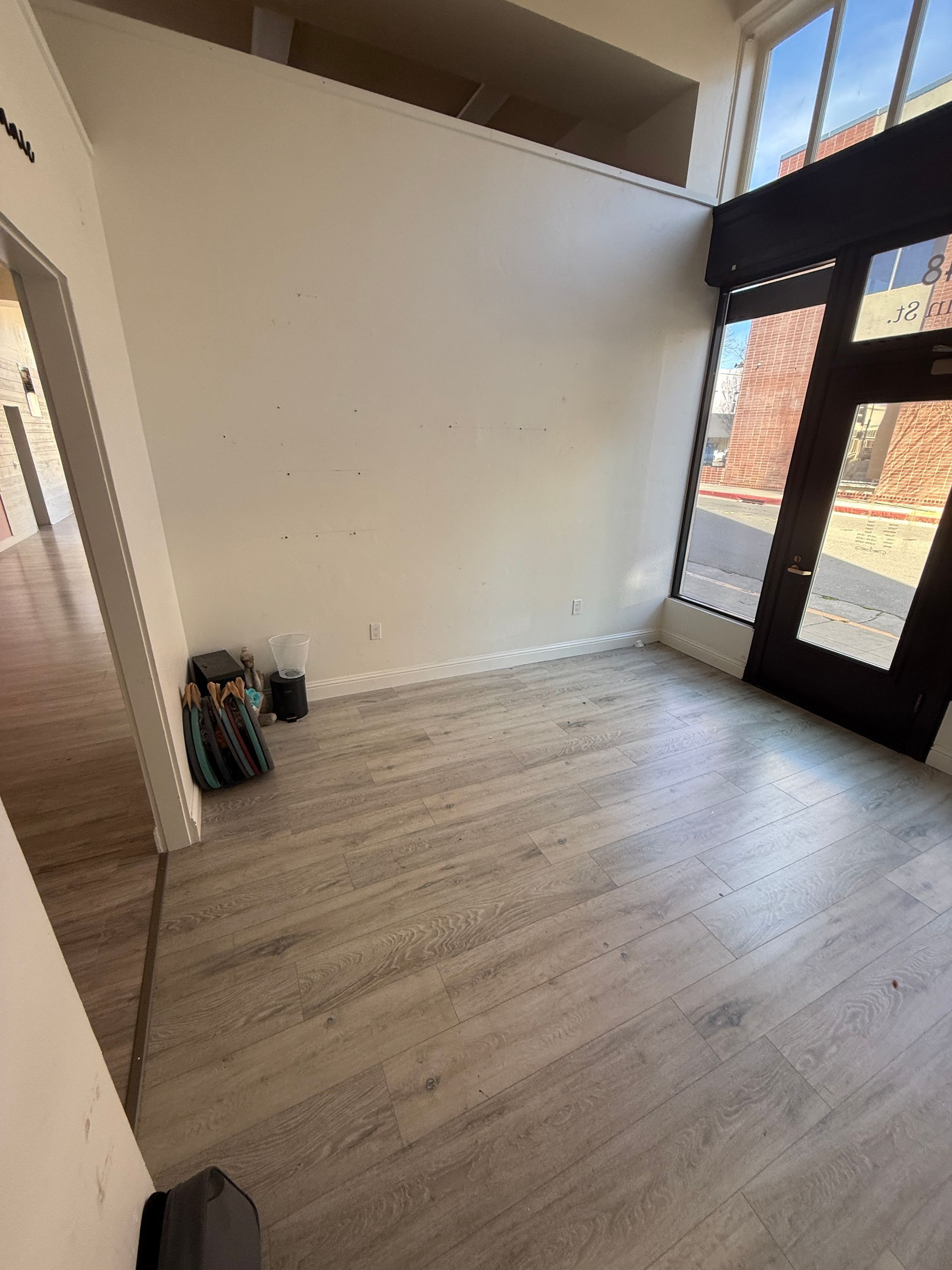 An empty room with a wooden floor and a large window.