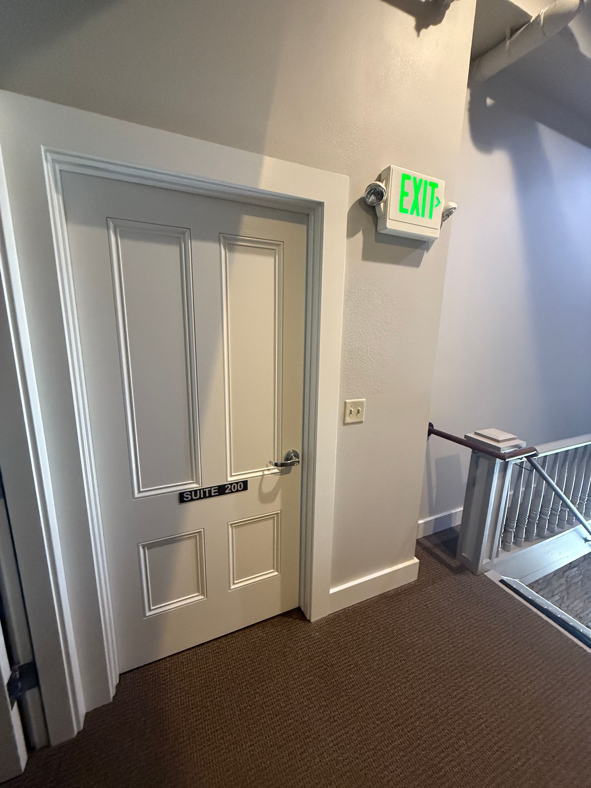 A white door with a green exit sign above it