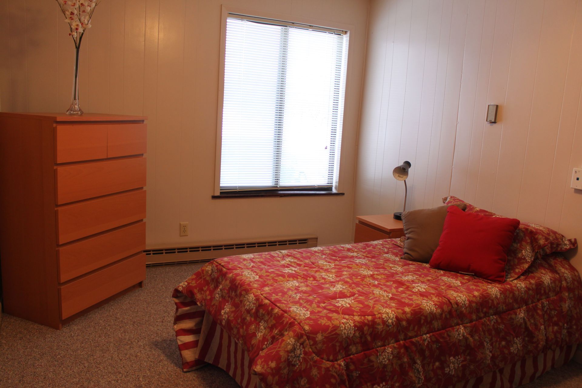 Photo showing a bedroom with a dresser and a tall window