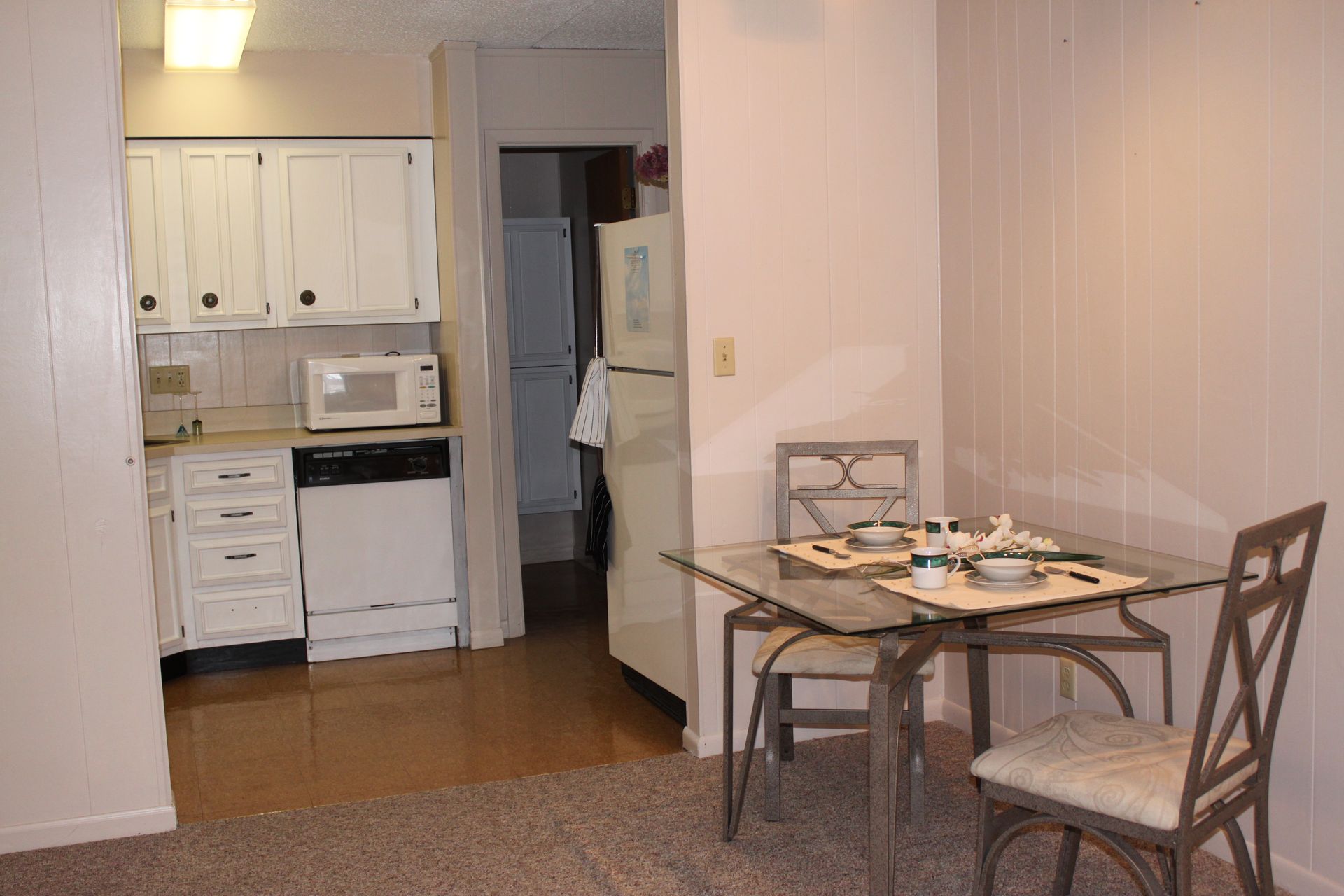 Photo showing a kitchen in the background with a small table in the foreground