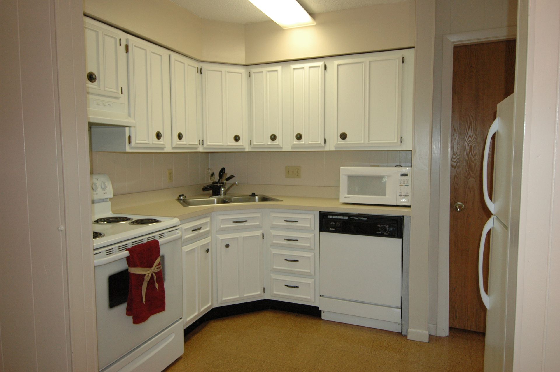 Photo showing a kitchen with a dishwasher, stove, microwave and refrigerator