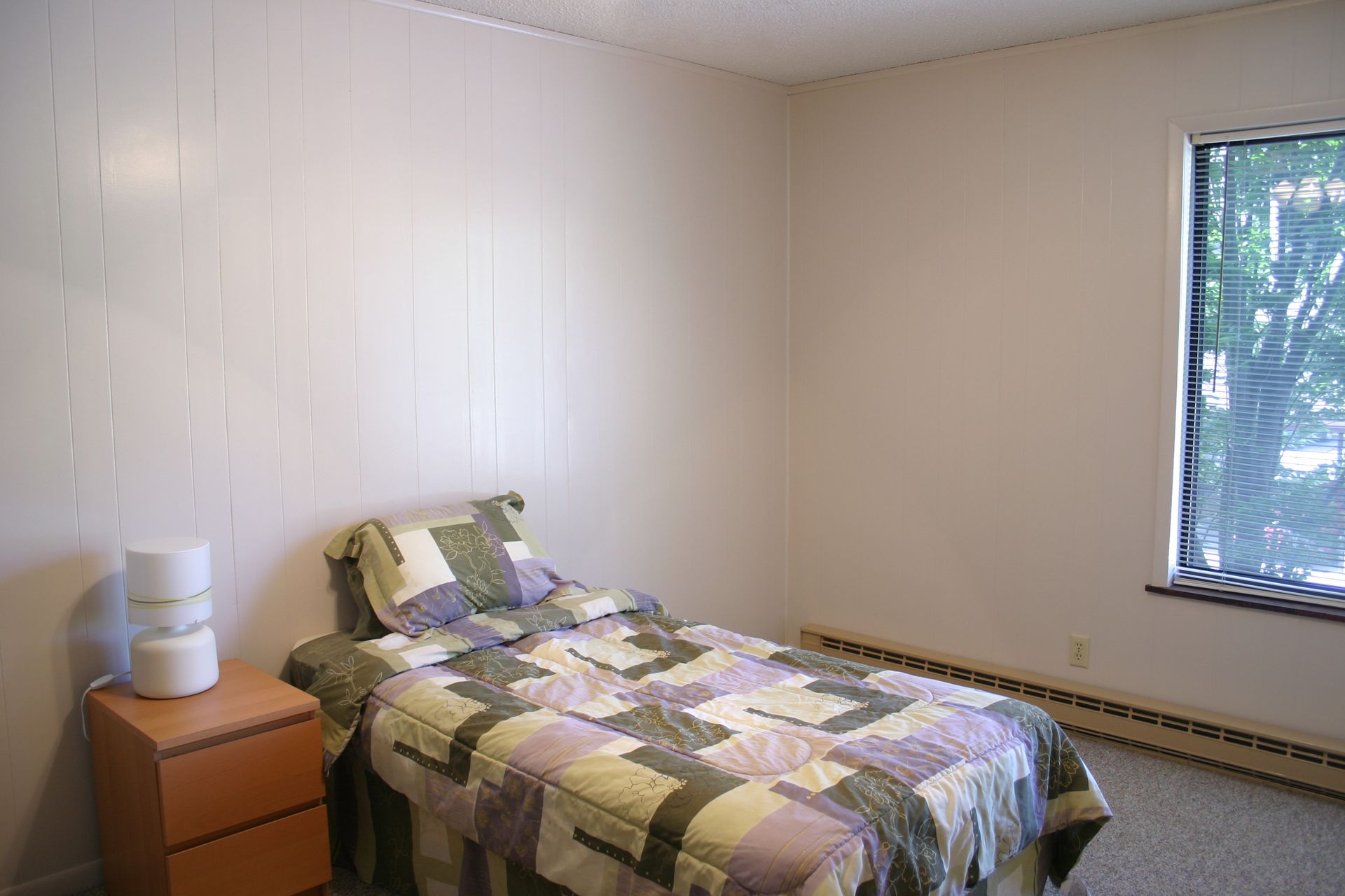 Photo showing a bedroom with plenty of space next to a bed