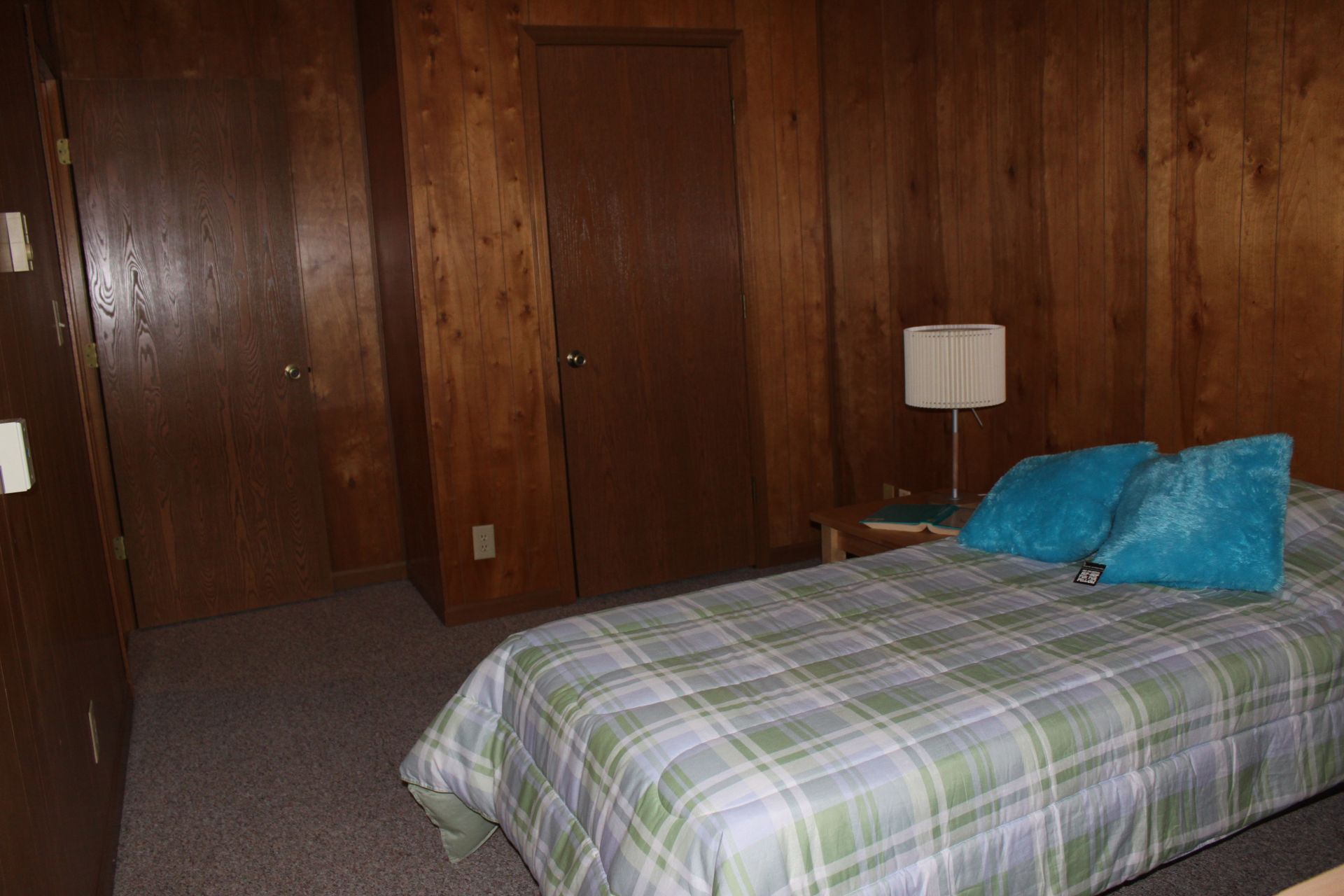 Photo showing a bedroom with wood-panel walls