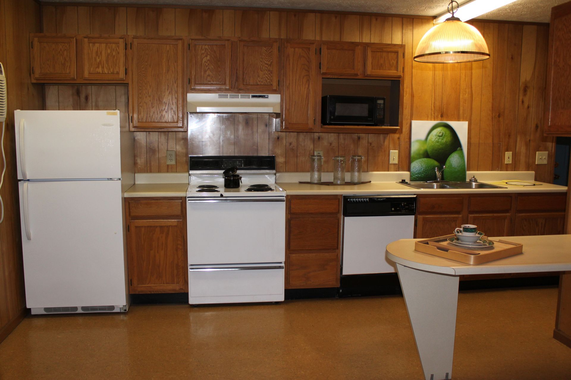 PHoto showing the kitchen with a stove, refrigerator and dishwahser