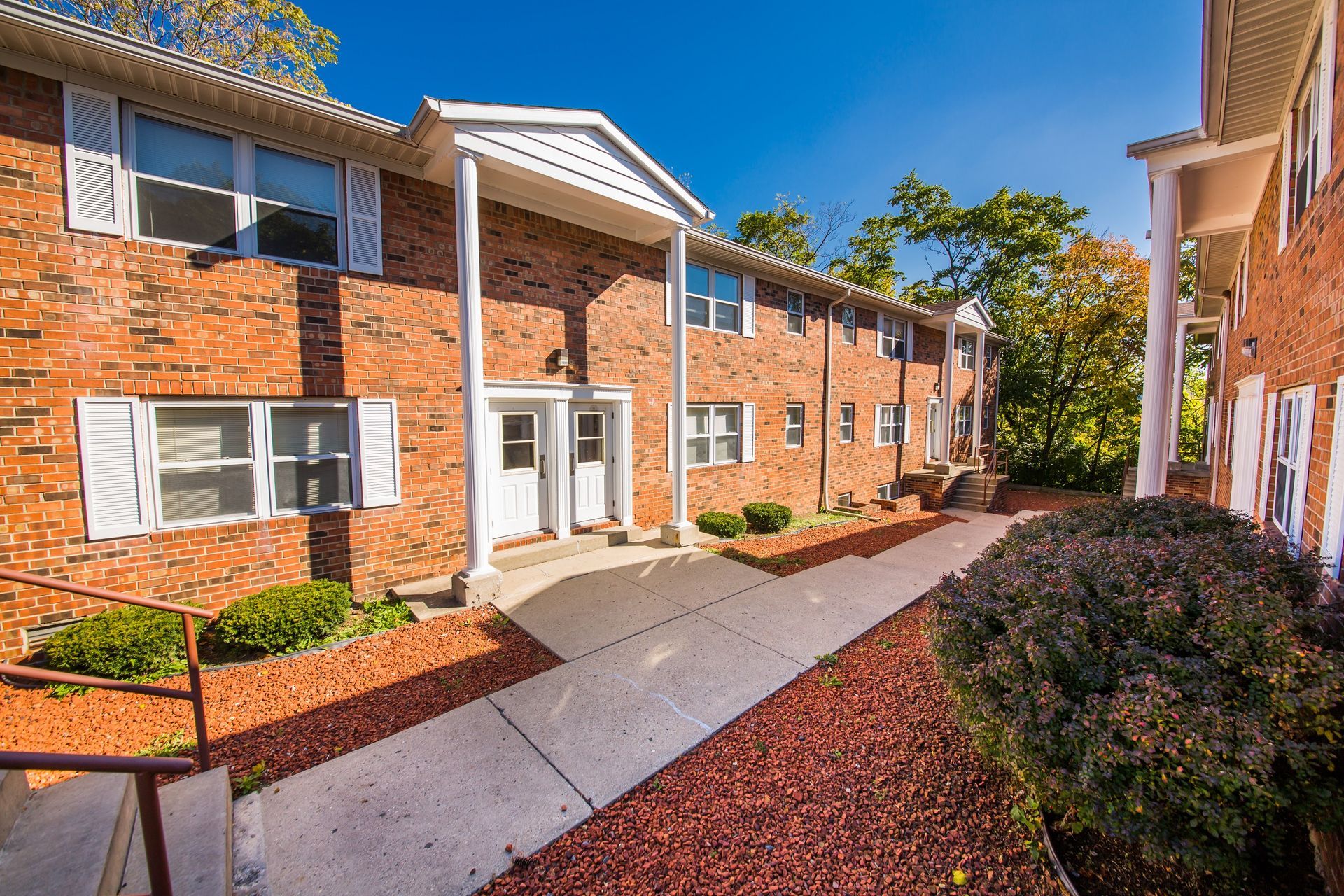 Photo showing a pair of buildings with the entrance to one seen in the middleground