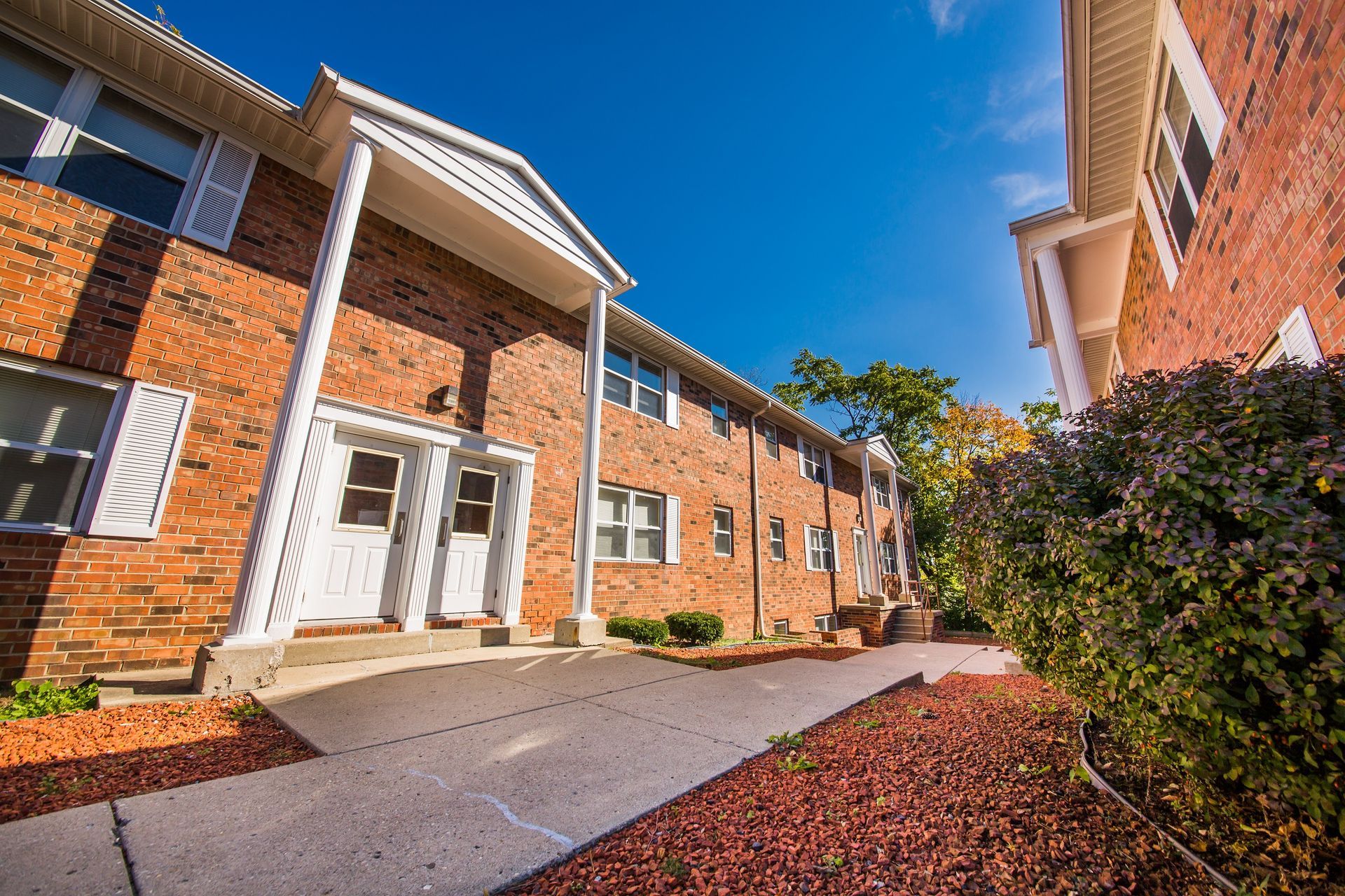 Photo showing a pair of buildings with the entrance of one seen in the middleground, taken from a lower angle
