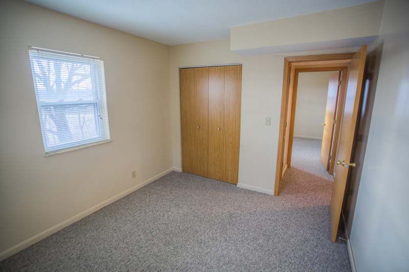 Photo showing a bedroom with another bedroom's entrance in the background