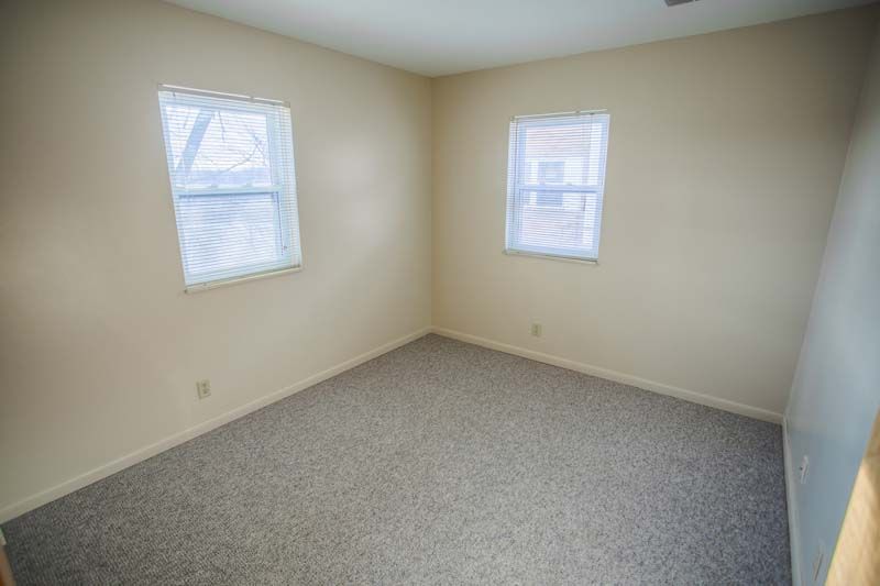 Photo showing a bedroom with two windows