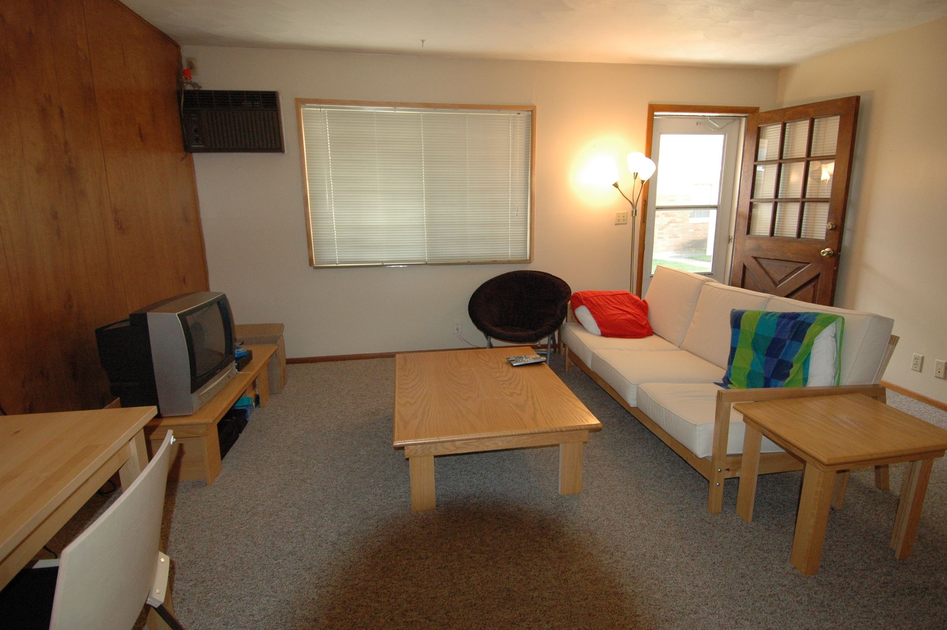 Photo showing a living room with a screen door in the background