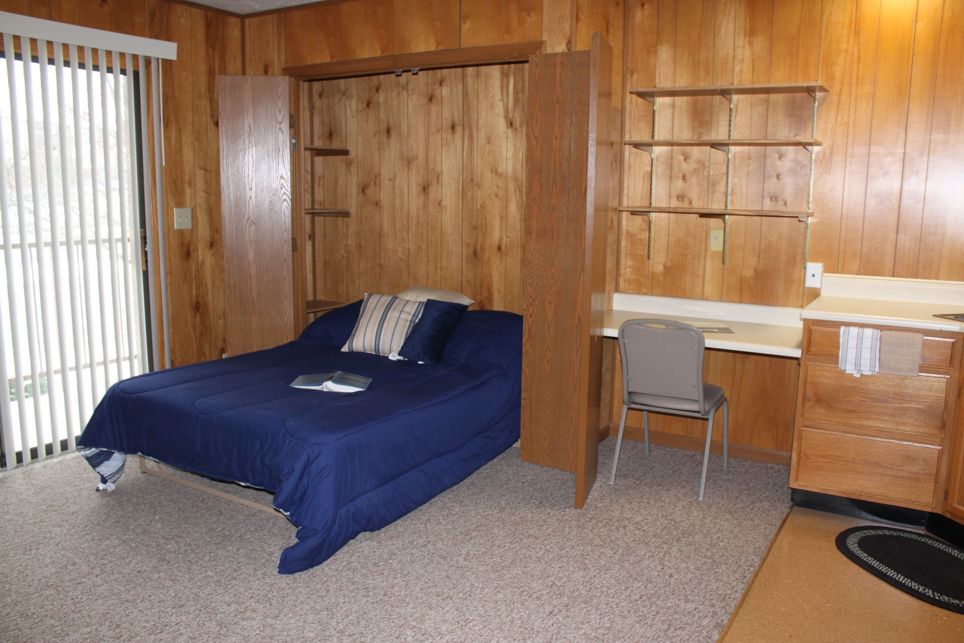 Photo showing a wall bed with a desk next to it