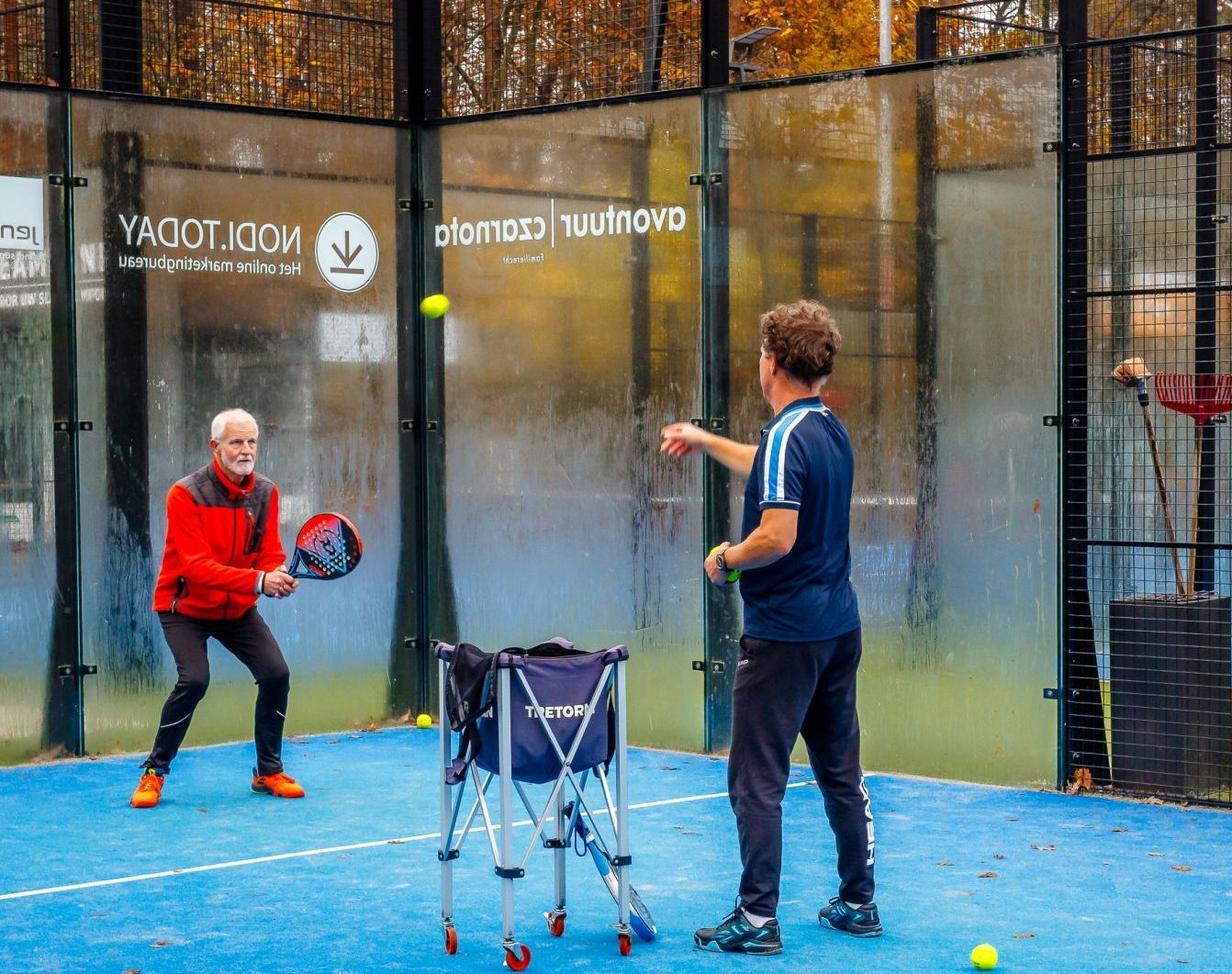Twee mannen spelen een potje paddel op een baan. individuele of coaching