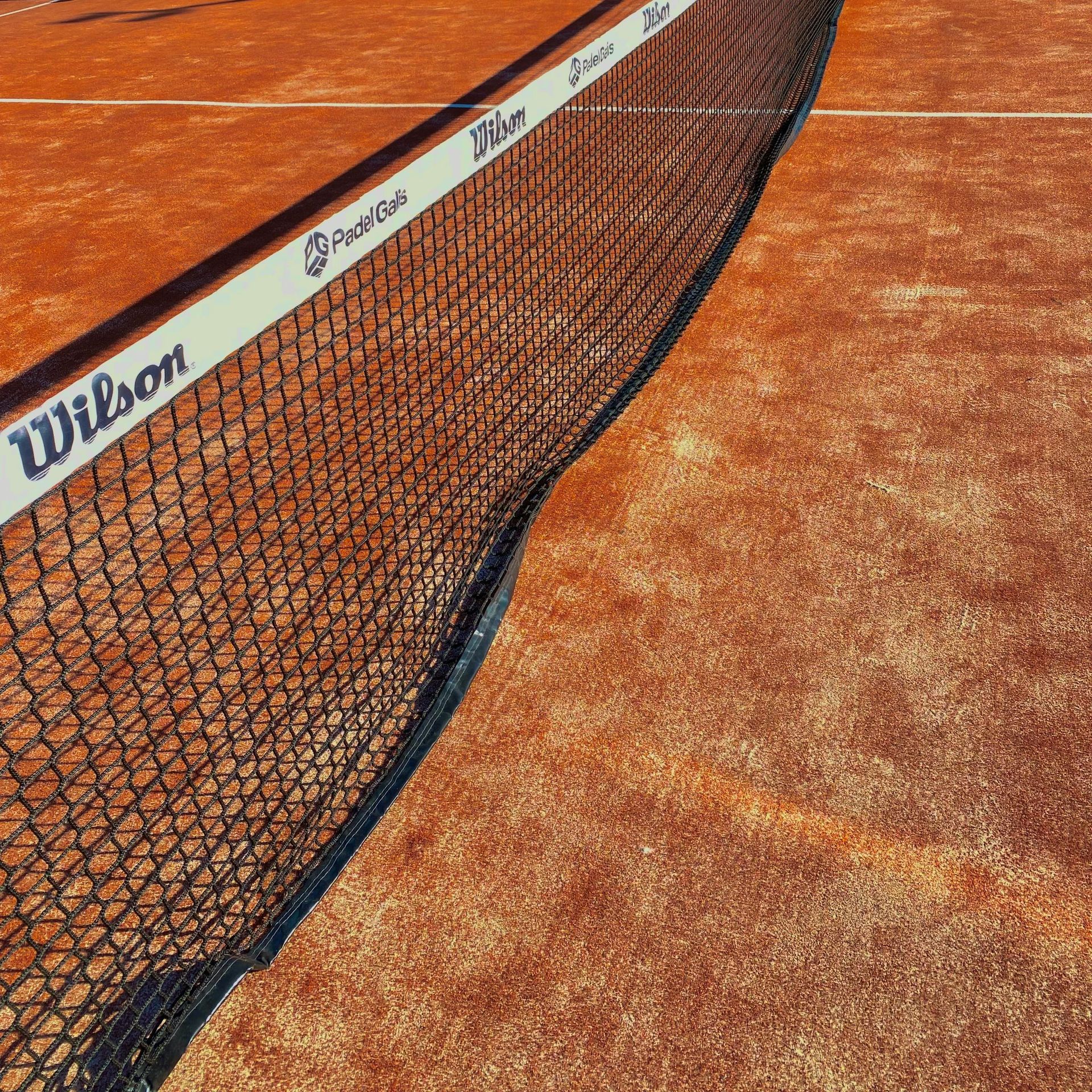 Een wilson tennisnet op een gravelbaan