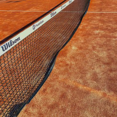 Een wilson tennisnet op een gravelbaan