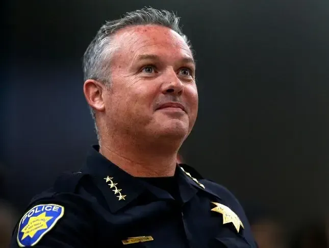 A man in a police uniform is looking up