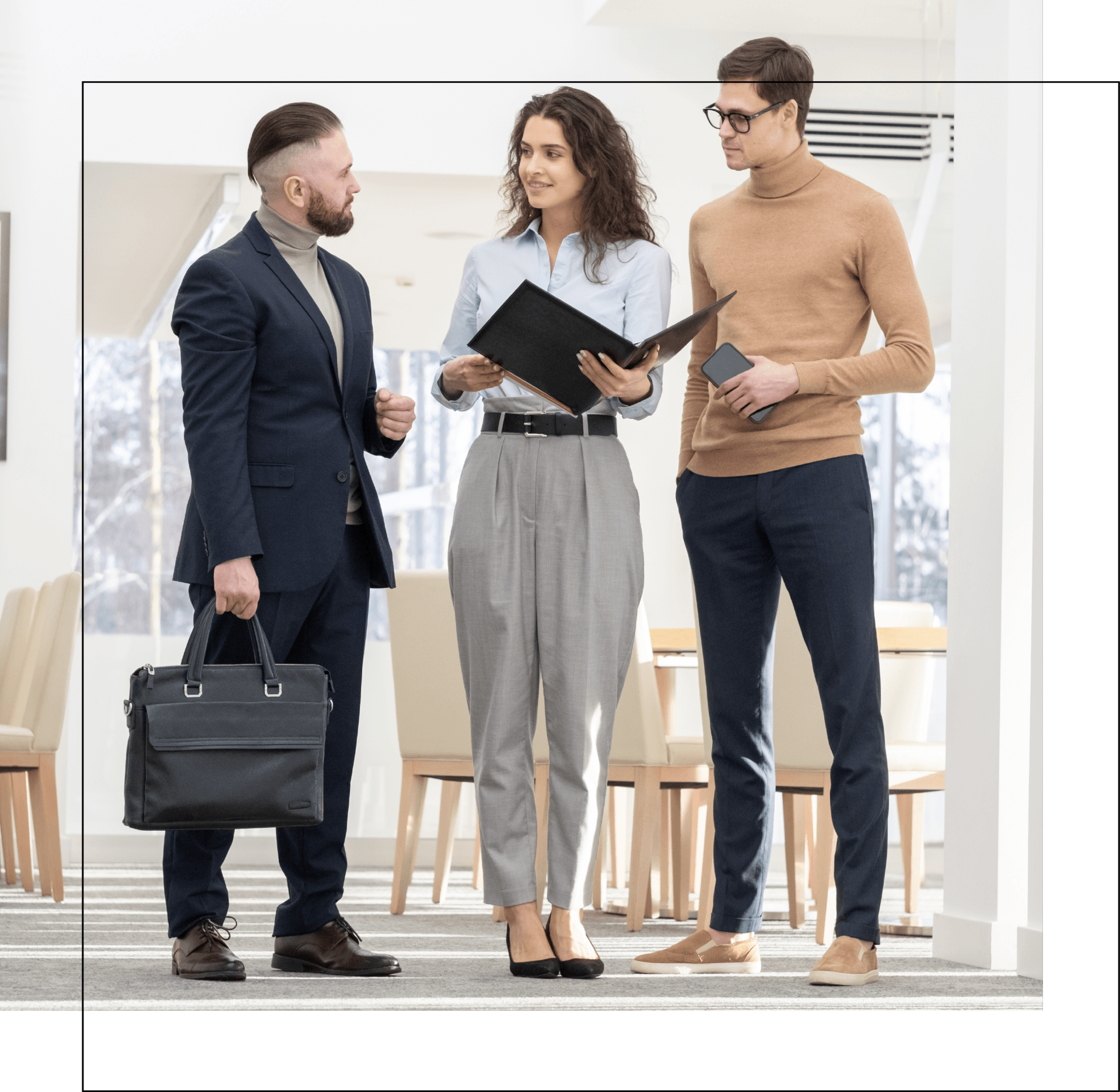 A group of people are standing next to each other in a room talking to each other.