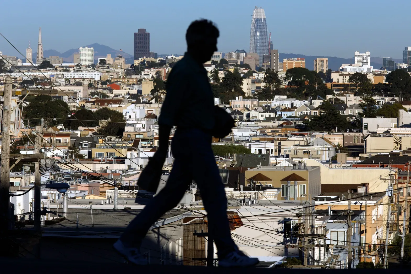 A silhouette of a man walking in a city