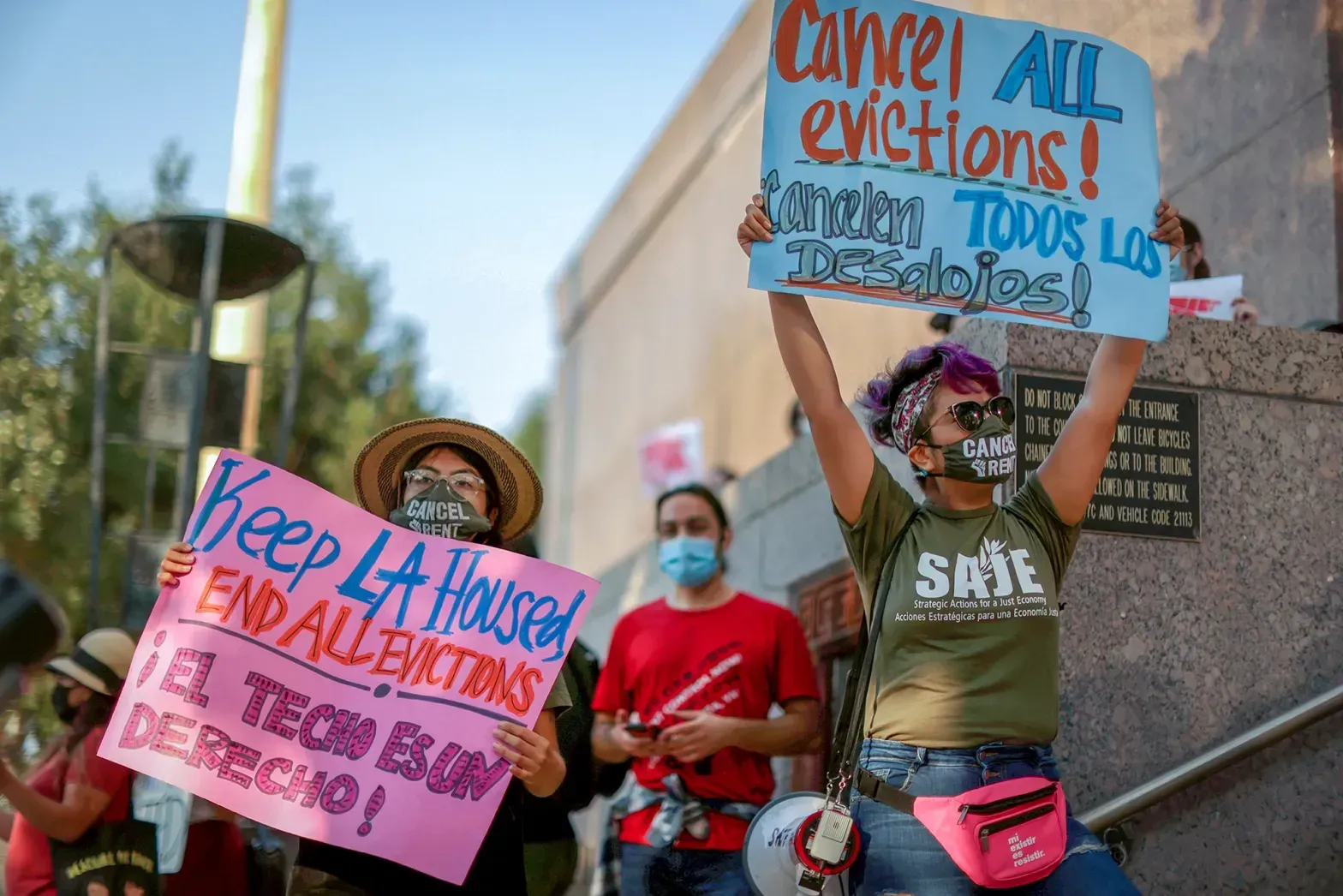 A woman is holding a sign that says `` cancel all evictions ''.